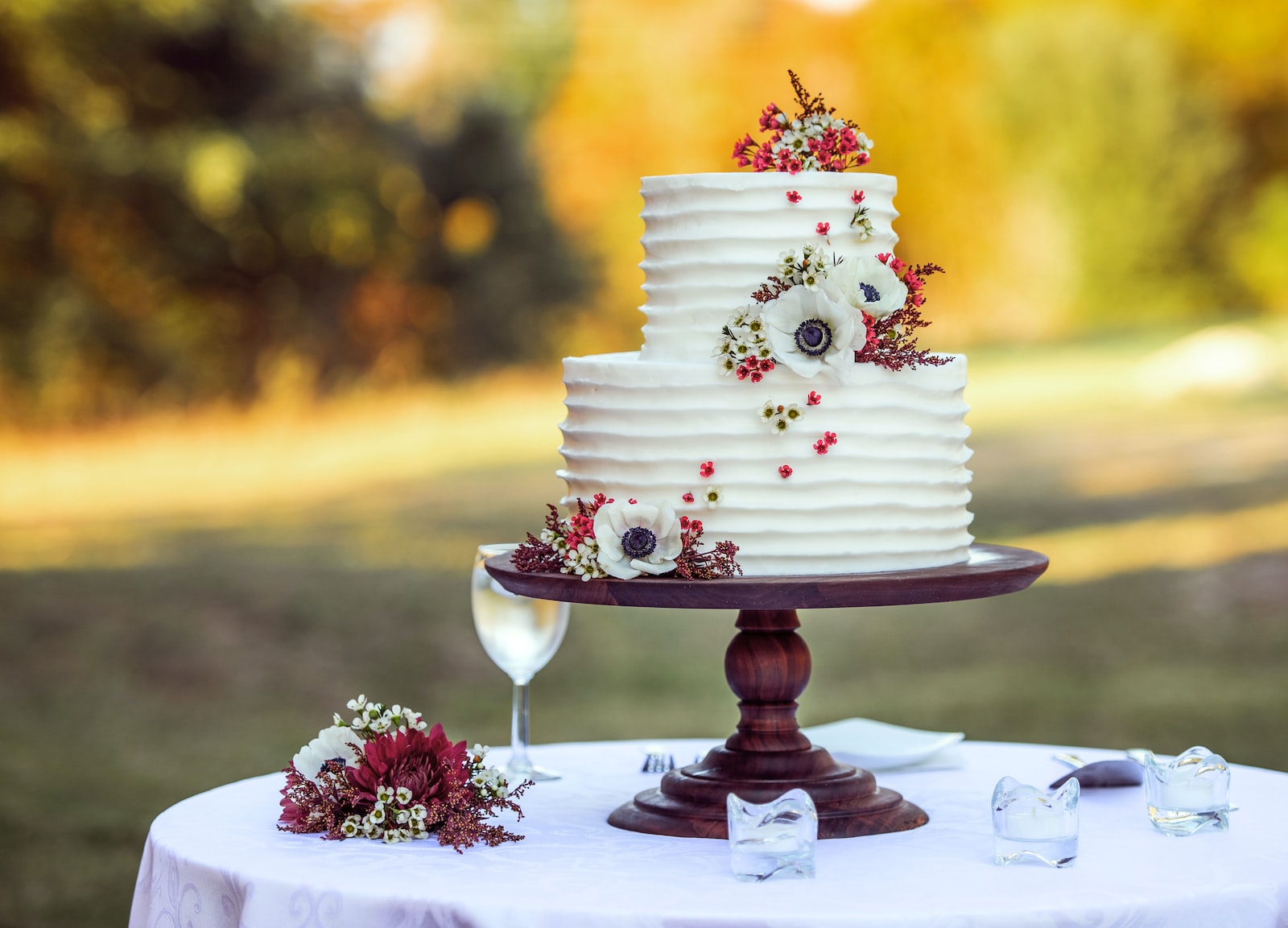 white and red floral cake on brown wooden stand